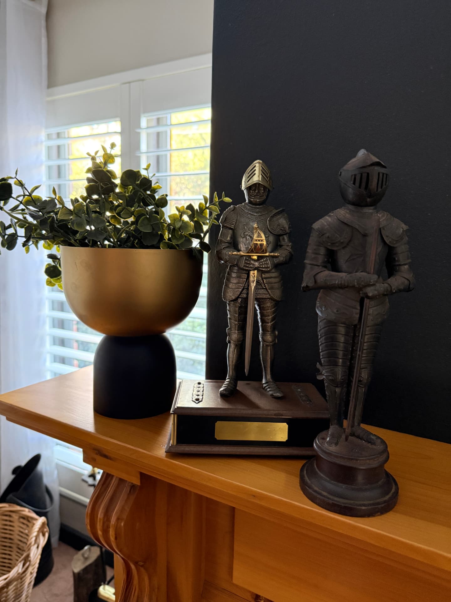 A carved wooden console with collected objects and a brass planter